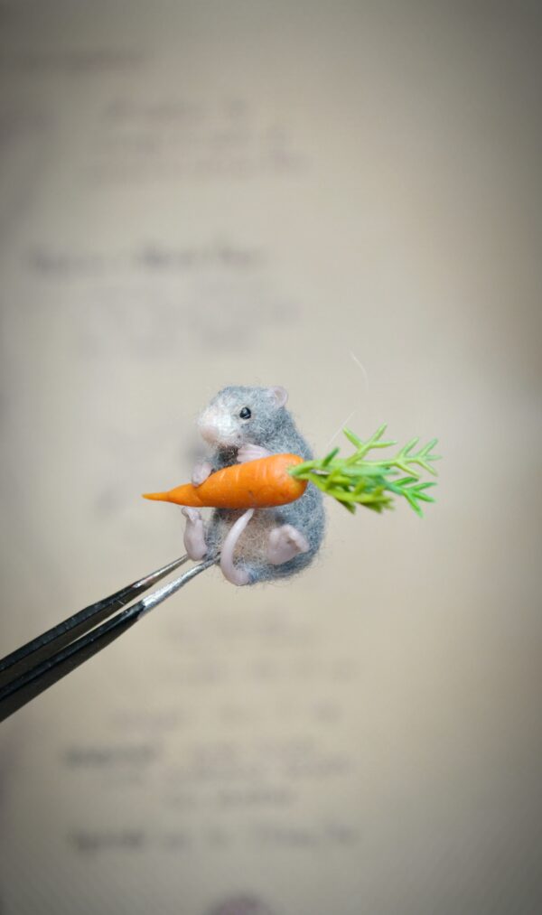 This tiny 2.5 cm wool mouse comes with its own miniature carrot! A sweet and expressive felted animal for collectors, fairy scenes, and dollhouse life.
