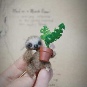 This 4 cm felted baby sloth comes with a tiny monstera plant! Fully poseable with wire limbs and turning head — a tropical treasure for miniature lovers.