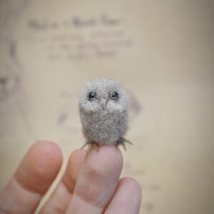 This 2.5 cm tall felted owlet is handmade from wool. A soft, fluffy miniature baby owl for collectors, dollhouse scenes, or woodland displays