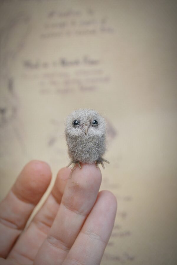 This 2.5 cm tall felted owlet is handmade from wool. A soft, fluffy miniature baby owl for collectors, dollhouse scenes, or woodland displays
