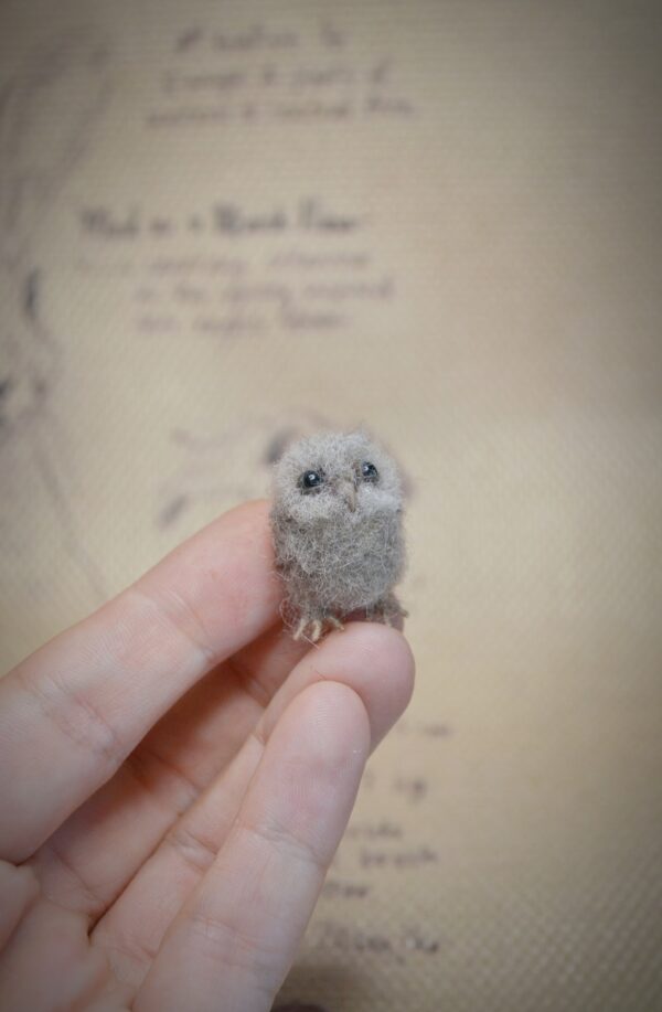 This 2.5 cm tall felted owlet is handmade from wool. A soft, fluffy miniature baby owl for collectors, dollhouse scenes, or woodland displays