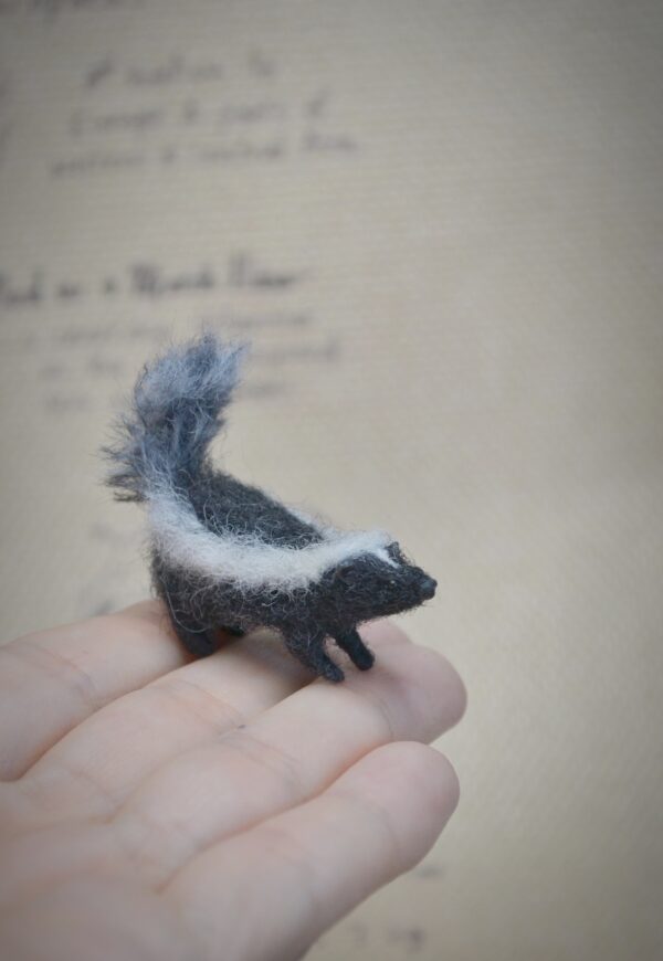 Handmade skunk miniature felted from natural wool. A charming woodland animal collectible for dollhouses, dioramas, and unique handmade gift lovers.