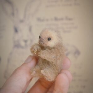 Handmade needle felted sloth miniature with movable limbs and a calm fixed expression. A charming wool collectible for animal lovers.