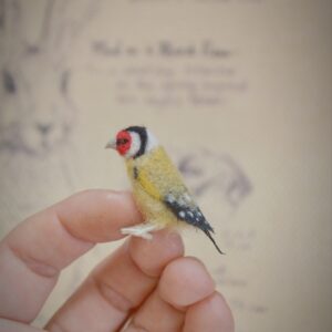 Handmade needle felted goldfinch miniature with vivid colors and delicate detailing. A charming wool collectible for bird lovers.