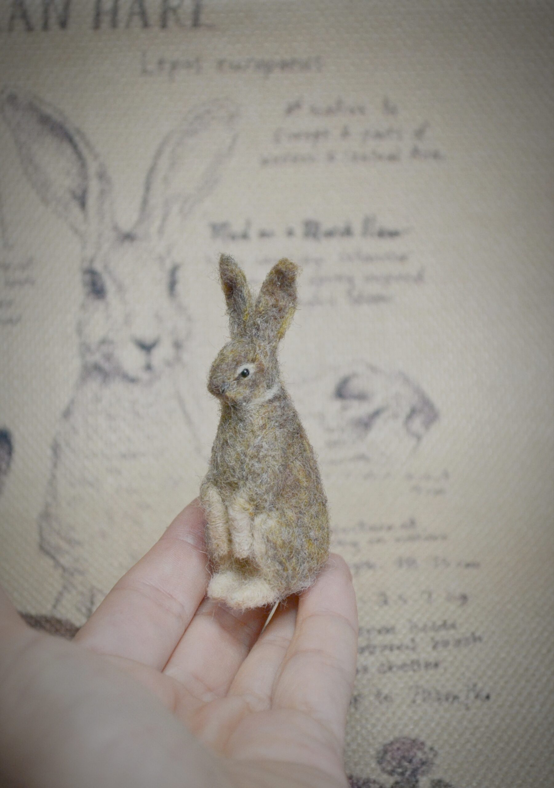 Handmade needle felted hare miniature crafted from natural wool. Soft textures, gentle shaping, and woodland charm in a tiny collectible.